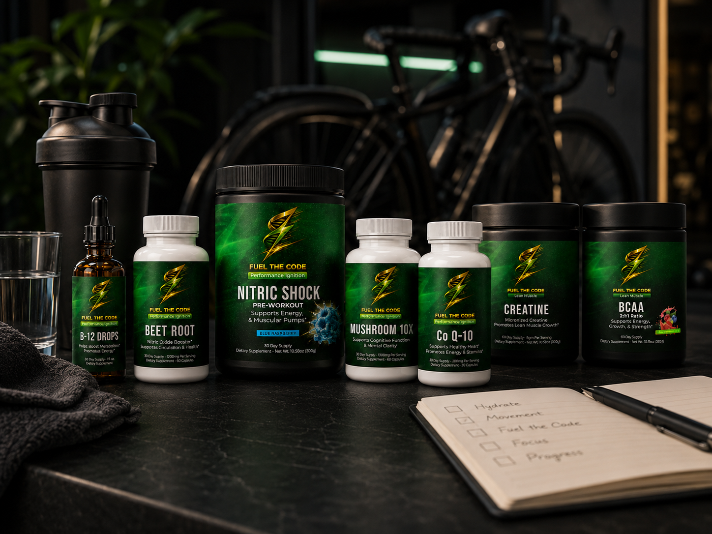 Fuel the Code supplement system arranged with a shaker, notebook, and cycling gear in the background